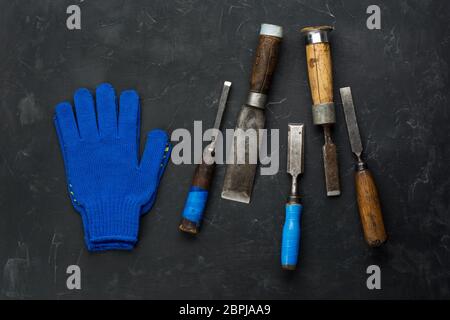 Carpenter Tools and working gloves on dark background. Minimal black. Stock Photo