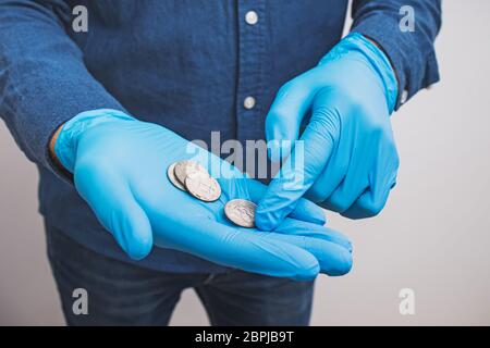 Male hand in gloves counting coins close-up. Stock Photo