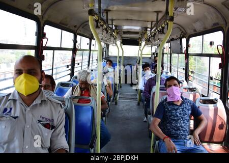 Passengers and a conductor using a Delhi Transport Corporation (DTC) bus while wearing face masks as a precaution, during the eased lockdown restrictions.As a preventive measure against the spread of the COVID-19, restrictions were imposed, the gov’t has eased some of the restrictions after several days of lockdown. Stock Photo