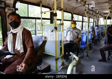 A driver and conductor on a Delhi Transport Corporation (DTC) bus, wearing a face mask as a precaution, during the eased lockdown restrictions.As a preventive measure against the spread of the COVID-19, restrictions were imposed, the gov’t has eased some of the restrictions after several days of lockdown. Stock Photo