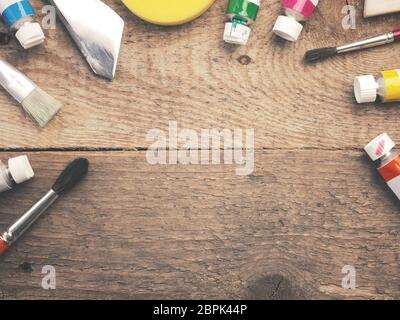 Assortment of different painter utensils on a rustic wooden table with space for your text in the center Stock Photo