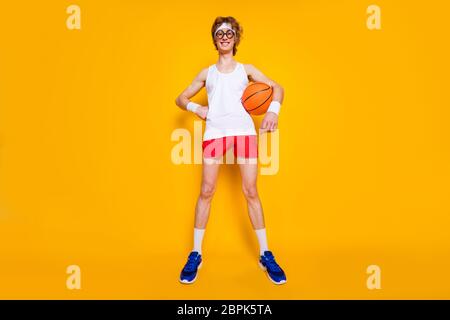 Full length body size view of nice funky successful cheerful cheery guy holding in hand orange ball amateur league season isolated over bright vivid Stock Photo