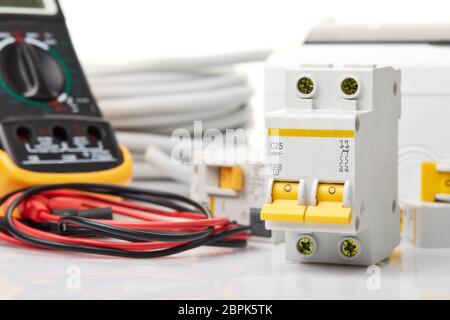 Automatic circuit breakers, distribution box, cable and digital tester on a white background. Electrical equipment. Accessories for electrical  protec Stock Photo