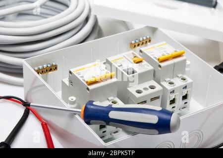 Automatic circuit breakers, distribution box, cable and screwdriver on a white background. Electrical equipment. Accessories for electrical  protectio Stock Photo