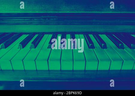 close-up view of the keys of a ancient ruined piano. Green and blue duotone effect Stock Photo