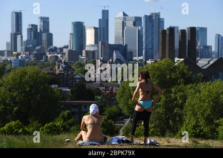Two women sunbathe and enjoy the hot weather in Greenwich Park, London, after the introduction of measures to bring the country out of lockdown. Stock Photo