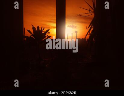 Dramatic industrial sunset through the office window background Stock Photo