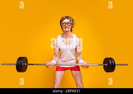 Portrait of his he nice attractive weak slim sad desperate guy lifting heavy barbell doing enduring work out isolated over bright vivid shine vibrant Stock Photo