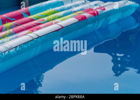 sunny pool scenery with air bed and mirroring water surface Stock Photo