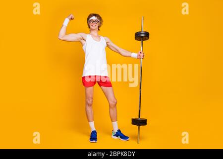 Full length body size view of his he nice attractive cheerful content slim sportive guy holding in hand barbell showing bicep work out isolated over Stock Photo