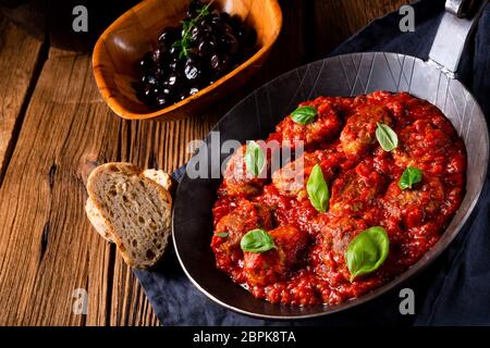 Baked mini meatballs in tomato sauce with basil Stock Photo