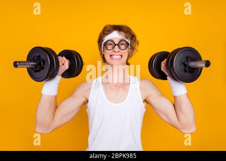 Close-up portrait of his he nice attractive funky cheerful cheery motivated guy sportsman lifting barbell doing good work out isolated over bright Stock Photo
