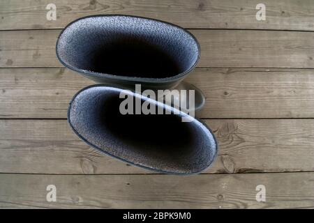 Rubber boots on the wooden floor. Abstract background image. View from above. Top view of farmer rubber boots standing on wooden floor Stock Photo