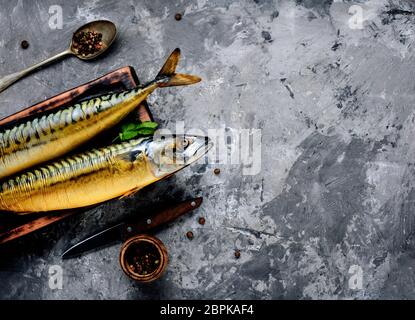 Smoked fish on kitchen board.Smoked mackerel.Mediterranean food Stock Photo