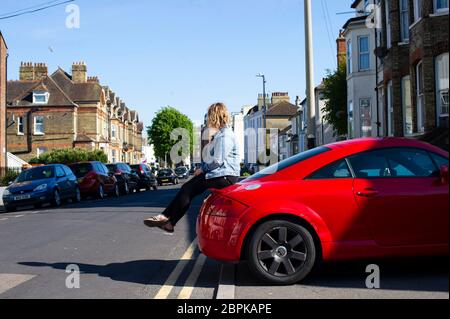 Woman sitting on the boot of a red Audi car Stock Photo