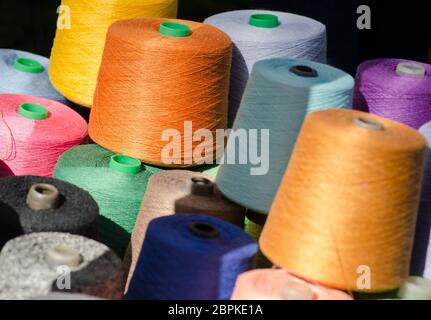 Colorful thread spools, one above the other. Coils with colurful threads. Stock Photo