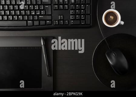 Total black desk with pc, tablet and cup of coffee Stock Photo