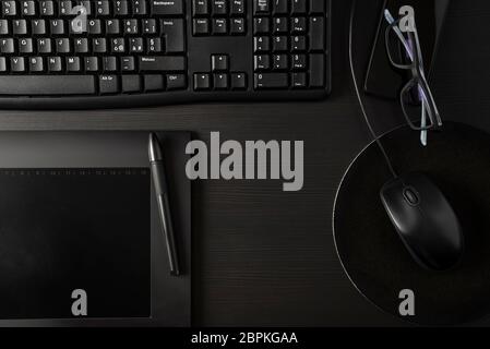 Total black desk with pc, tablet and personal items Stock Photo
