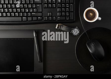 Total black desk with pc, tablet and cup of coffee Stock Photo