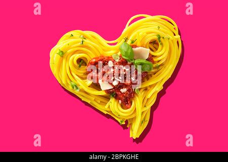 Decorative heart-shaped Italian pasta portion, formed of cooked spaghetti, topped with tomatoes, basil, and parmesan cheese, viewed in close-up, from Stock Photo