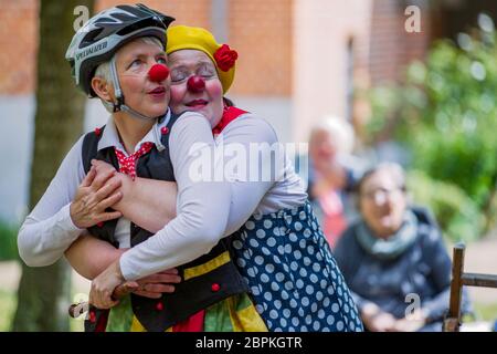 Schwerin, Germany. 19th May, 2020. Kerstin Daum as 'Kiki' (back) and Ines Vowinkel (front) as 'Fine' make music as clinic clowns in front of the 'Augustenstift' nursing home which is closed to visitors. Due to corona protection measures, the two clowns are only allowed to play in front of balconies and on terraces in front of the house. Credit: Jens Büttner/dpa-Zentralbild/dpa/Alamy Live News Stock Photo