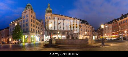The oldest square Gammeltorv or Old Market with Caritas Fountain in the center during morning blue hour, Copenhagen, capital of Denmark Stock Photo