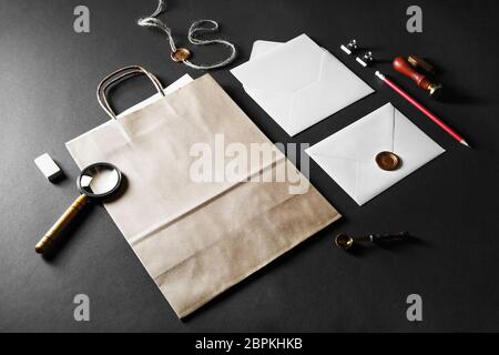 Blank paper bag, envelopes and retro stationery on black paper background. Stock Photo