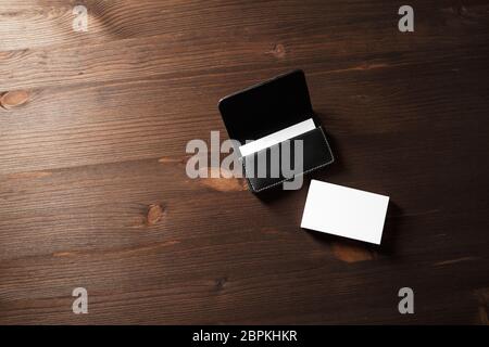 Blank business cards and leather business card holder on wooden background. Space for text. Stock Photo