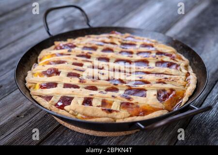 sweet pie in iron pan on wooden ground Stock Photo
