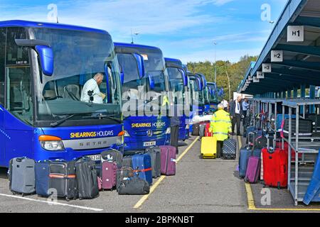 Outdoor luggage logistics hub for sorting & loading passengers holiday tour suitcases onto Shearings coaches Scratchwood Services London England UK Stock Photo