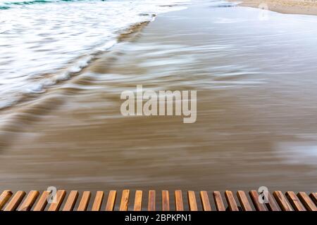 Sea surf rolling ashore after sunset, blurry with a long exposure Stock Photo