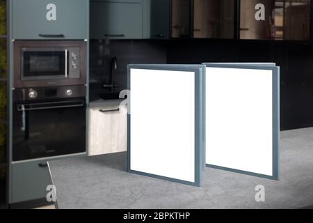 Blank mockup book brochure catalog on stoneware countertop with advertising copyspace over out of focus upscale Aqua Menthe kitchen in luxury home wit Stock Photo