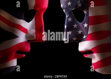 USA and GB face off head to head concept with human mask outlines covered in national flags symbols. Black background space for text Stock Photo
