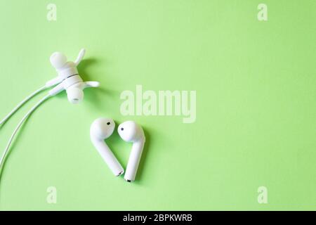 White headphones with a wire on a yellow background. The concept of gadgets. Stock Photo
