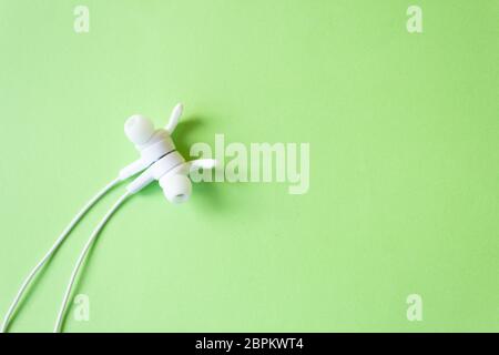 White headphones with a wire on a yellow background. The concept of gadgets. Stock Photo
