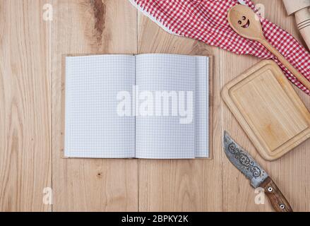open empty notebook with white sheets and a kitchen wooden spoon on the table, top view Stock Photo