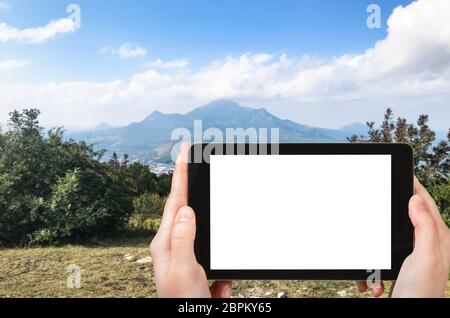 travel concept - tourist photographs of five tops of Mount Beshtau from viewpoint on top Mashuk mount in Pyatigorsk city of Russia on smartphone with Stock Photo
