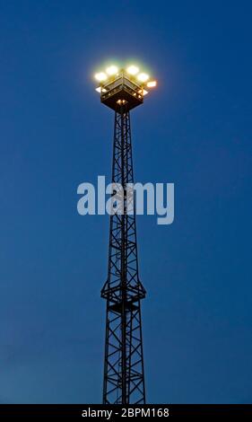 shining  flood light tower before blue night sky in the port of Rostock, Germany Stock Photo
