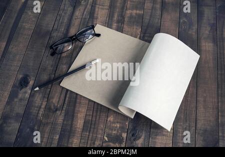Booklet with blank pages, pencil and glasses on vintage wood table background. Stock Photo