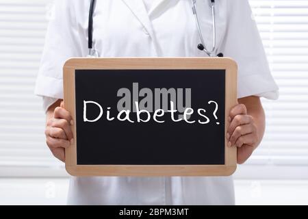Close-up Of A Female Doctor Holding Wooden Slate With Text Diabetes In The Clinic Stock Photo