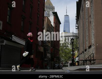 New York, United States. 19th May, 2020. A woman wears a protective face mask while crossing a street with a view of One World Trade Center in the Chinatown section of Manhattan during the COVID-19 Pandemic in New York City on Tuesday, May 19, 2020. The U.S. Coronavirus death toll now tops 90,000 and the number of reported cases reaches 1.5 million. Photo by John Angelillo/UPI Credit: UPI/Alamy Live News Stock Photo