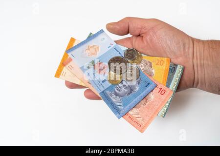 some Malaysian Ringgit banknotes and coins in the hand Stock Photo