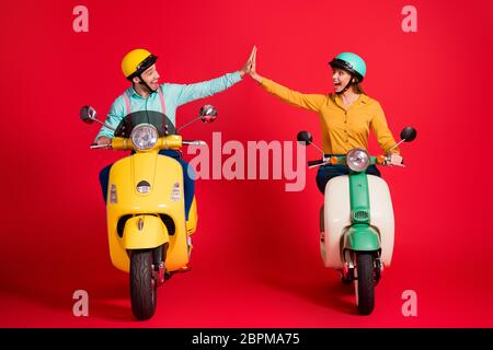 Portrait of his he her she nice attractive lovely glad lucky ecstatic cheerful cheery couple riding moped giving high five having fun isolated over Stock Photo