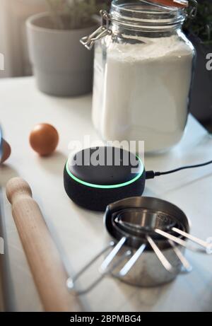 Woman Using Touch Screen on a Digital Tablet In The Kitchen At Home on a Chopping Board Stock Photo