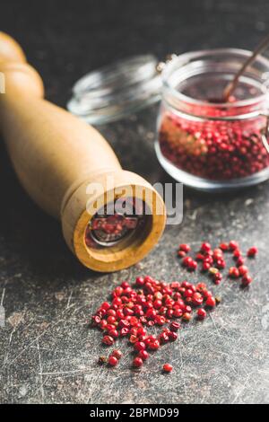 Dried pink peppercorn on old kitchen table. Stock Photo