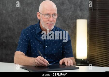 Mature graphic designer using digitized pen Stock Photo