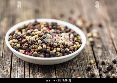 Different types of dried peppercorn in bowl. Stock Photo