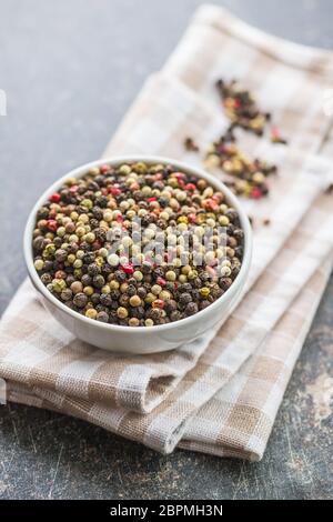 Different types of dried peppercorn in bowl. Stock Photo