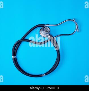 black medical phonendoscope on blue background Stock Photo