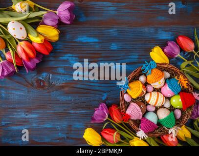 Easter holiday postcard with empty space for your text and fresh tulip flowers on blue painted wooden planks Stock Photo